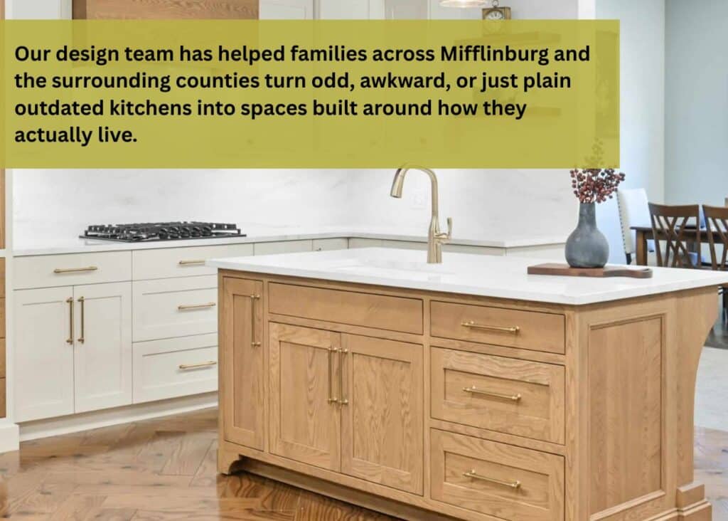 Custom kitchen cabinetry with a natural wood island, white perimeter cabinets, floating shelves, and brass hardware